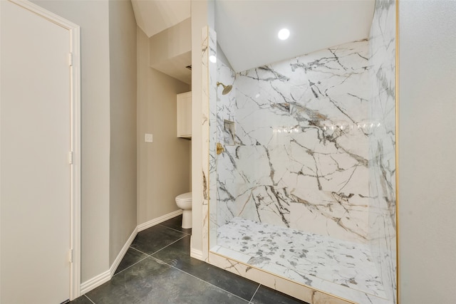 bathroom featuring a tile shower and toilet