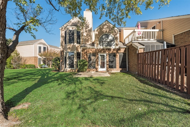 back of property with a balcony and a lawn