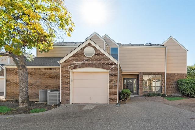 view of front of property featuring a garage and central AC unit