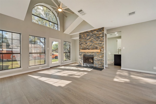 unfurnished living room with a fireplace, light wood-type flooring, and ceiling fan