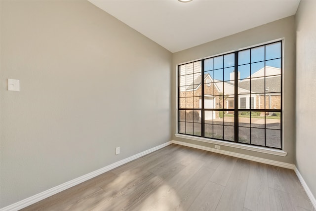 unfurnished room featuring hardwood / wood-style floors and lofted ceiling