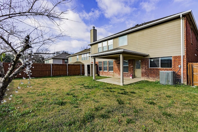 rear view of property with central AC unit, a patio, and a yard