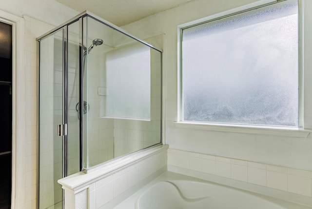 bathroom with a healthy amount of sunlight and separate shower and tub