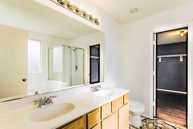 bathroom featuring hardwood / wood-style floors, a shower with door, vanity, and toilet