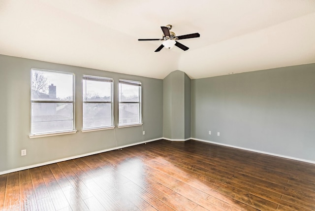 empty room featuring dark hardwood / wood-style flooring, ceiling fan, and vaulted ceiling