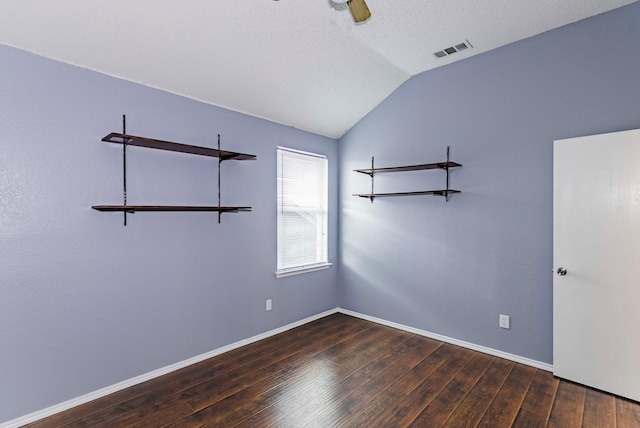 spare room featuring vaulted ceiling, ceiling fan, a textured ceiling, and dark hardwood / wood-style flooring