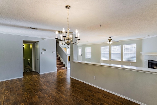 interior space featuring dark hardwood / wood-style flooring, a textured ceiling, a tile fireplace, and crown molding