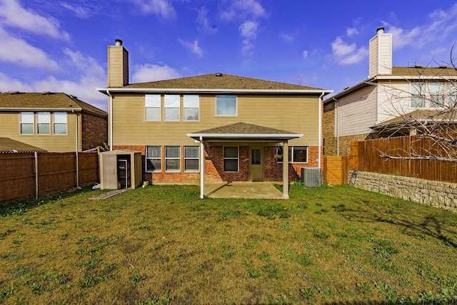 back of house featuring central air condition unit, a lawn, and a patio area