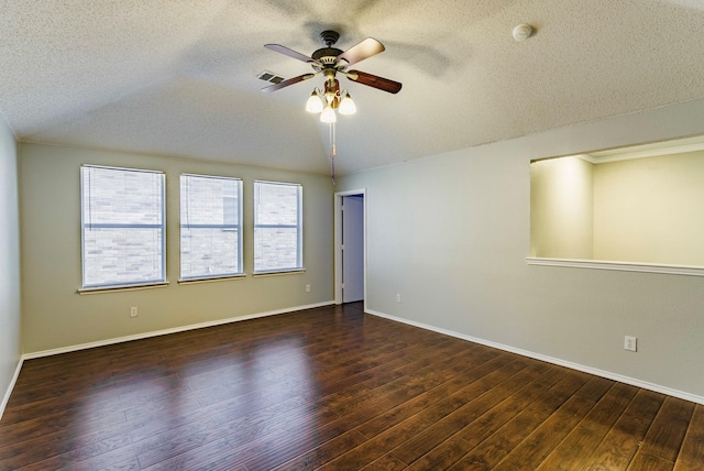 empty room featuring dark wood-type flooring, plenty of natural light, and a textured ceiling