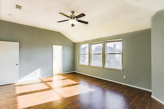 empty room with dark hardwood / wood-style flooring, ceiling fan, and vaulted ceiling