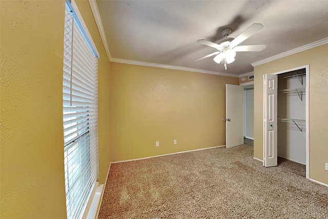 unfurnished bedroom featuring carpet, ceiling fan, crown molding, and a closet