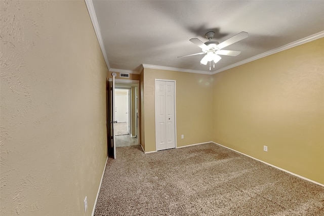 unfurnished bedroom featuring ceiling fan, a closet, carpet floors, and ornamental molding