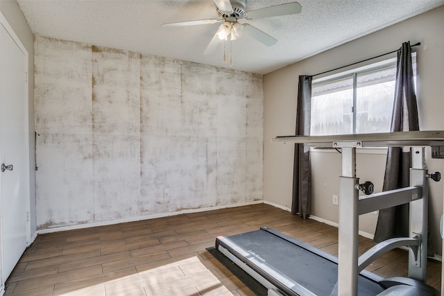 workout area with a textured ceiling, hardwood / wood-style flooring, and ceiling fan