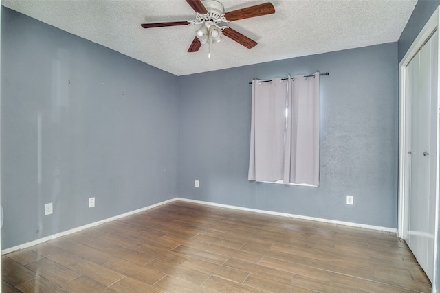 empty room featuring ceiling fan, a textured ceiling, and light wood-type flooring