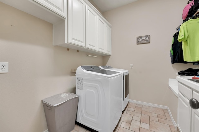 laundry room with cabinets, light tile patterned floors, and separate washer and dryer