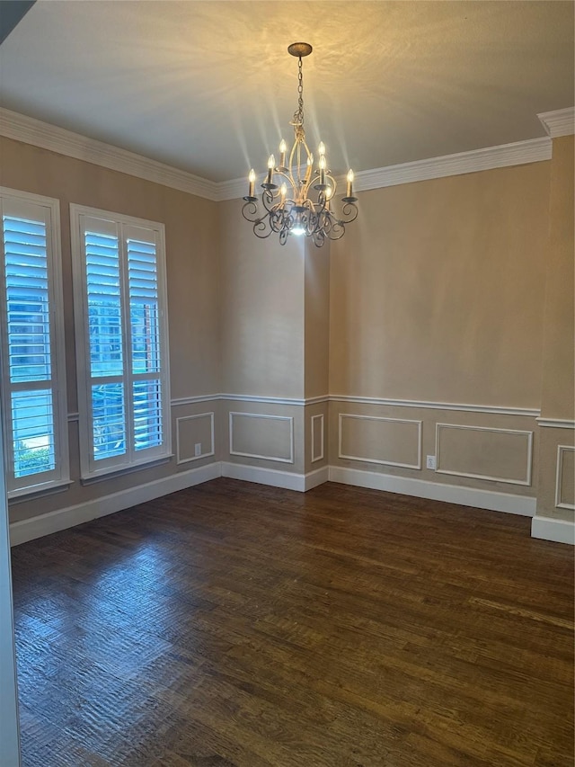 empty room with an inviting chandelier, dark wood-type flooring, and crown molding