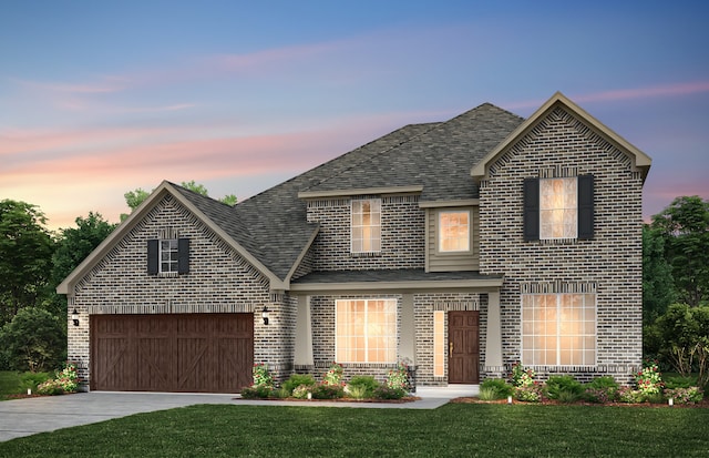 front facade featuring a garage and a lawn