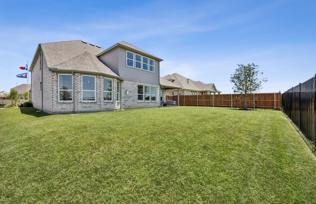 rear view of house featuring a yard