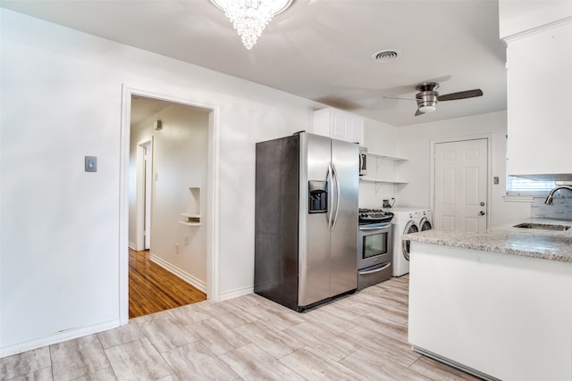 kitchen featuring sink, stainless steel appliances, independent washer and dryer, light hardwood / wood-style floors, and white cabinets