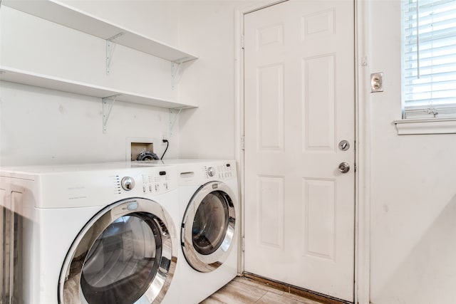 laundry area featuring washing machine and dryer and light hardwood / wood-style flooring