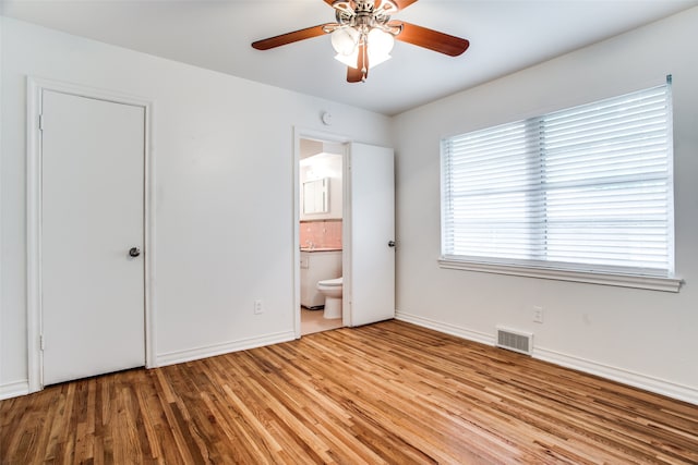 unfurnished bedroom with ensuite bathroom, ceiling fan, and light hardwood / wood-style floors