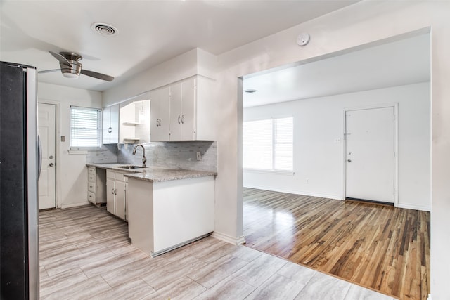 kitchen featuring white cabinetry, light hardwood / wood-style flooring, and a wealth of natural light