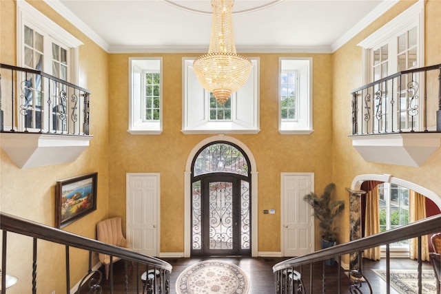 foyer featuring wood-type flooring, a healthy amount of sunlight, and crown molding