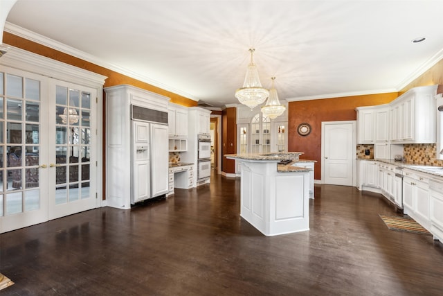 kitchen featuring french doors, a center island, white cabinets, decorative backsplash, and decorative light fixtures