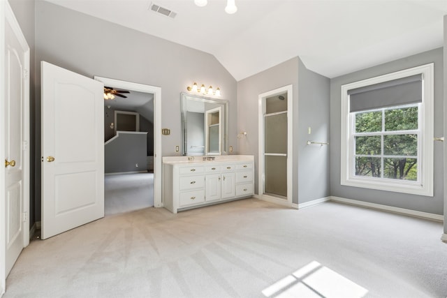 bathroom with a shower with door, vanity, ceiling fan, and vaulted ceiling