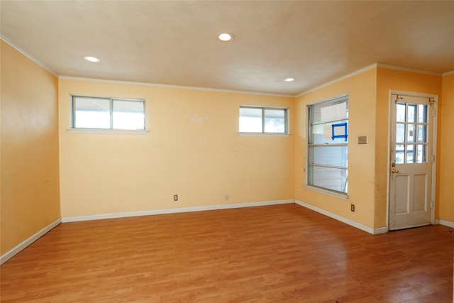 empty room with hardwood / wood-style flooring and crown molding