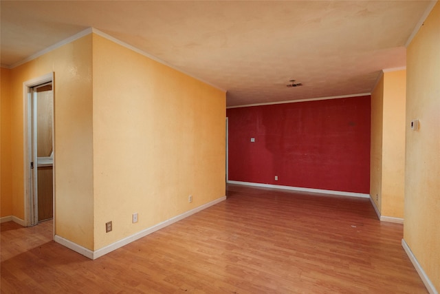 empty room featuring light hardwood / wood-style floors and crown molding