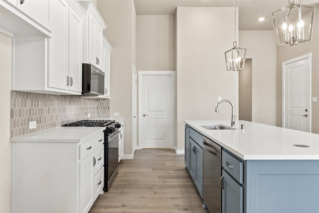 kitchen featuring a chandelier, stainless steel appliances, a sink, and light countertops