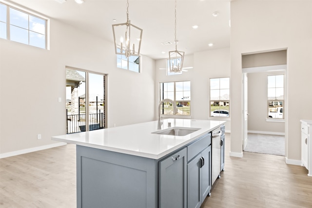 kitchen with light wood-style floors, gray cabinets, light countertops, and a sink