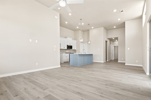 unfurnished living room with baseboards, visible vents, ceiling fan, and light wood finished floors