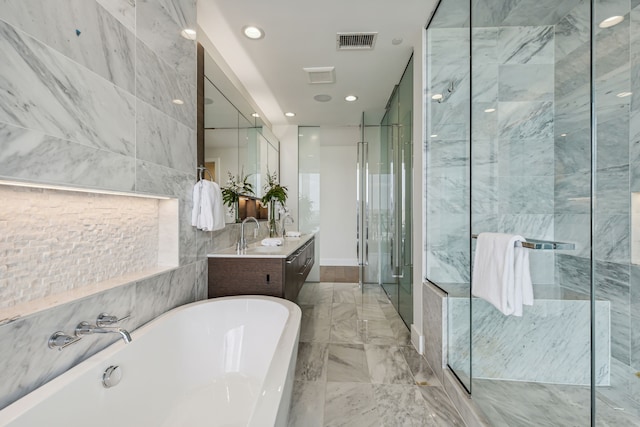 bathroom featuring shower with separate bathtub, vanity, and tile walls