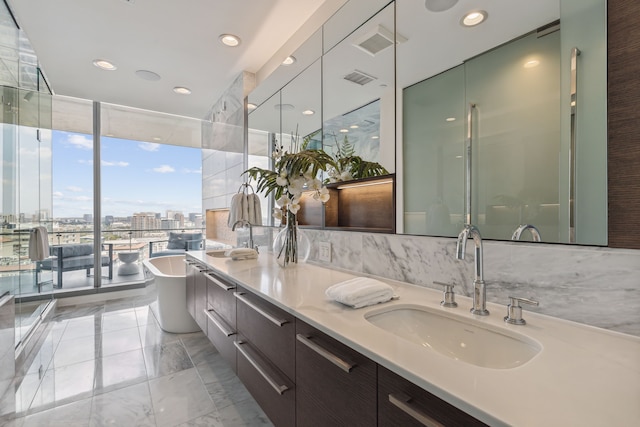 bathroom featuring a wall of windows, vanity, and a bath