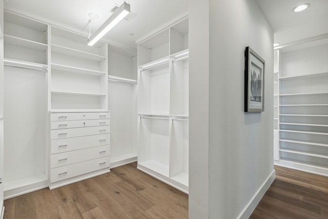 walk in closet with dark wood-type flooring