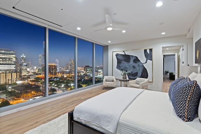 bedroom featuring floor to ceiling windows, hardwood / wood-style flooring, and ceiling fan