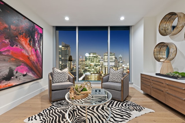 living area featuring a wall of windows and light hardwood / wood-style flooring