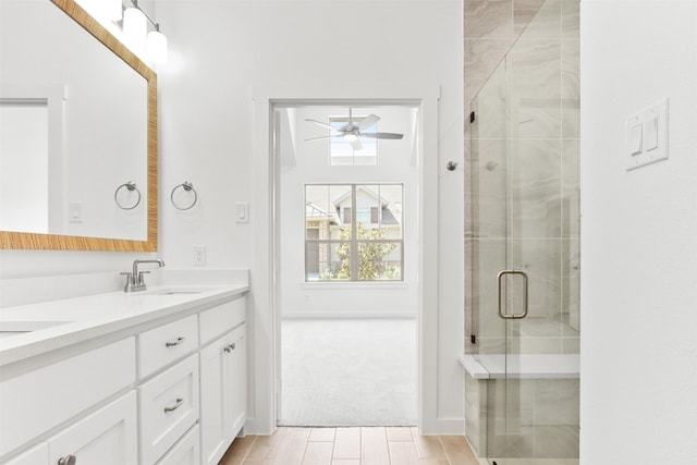 bathroom featuring hardwood / wood-style floors, an enclosed shower, vanity, and ceiling fan