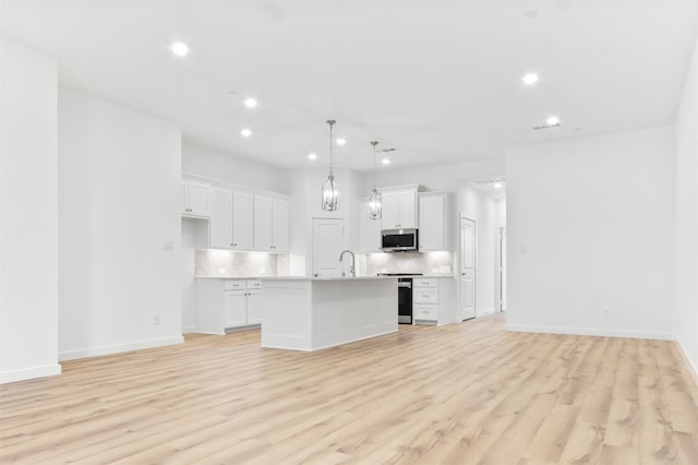 kitchen featuring an island with sink, white cabinetry, and light hardwood / wood-style flooring