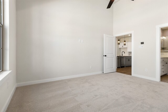 kitchen with light wood-type flooring, hanging light fixtures, sink, white cabinets, and a kitchen island with sink