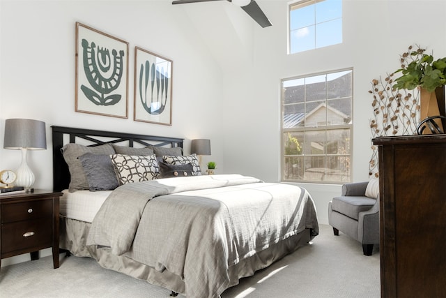 carpeted bedroom featuring a towering ceiling and ceiling fan