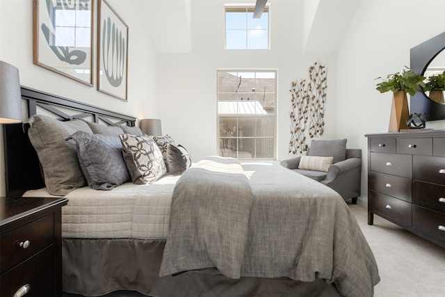 bedroom featuring light carpet and a towering ceiling