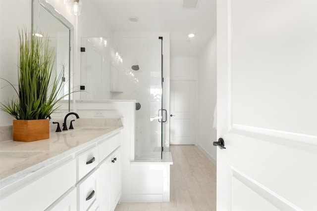 bathroom featuring vanity, hardwood / wood-style flooring, and a shower with shower door