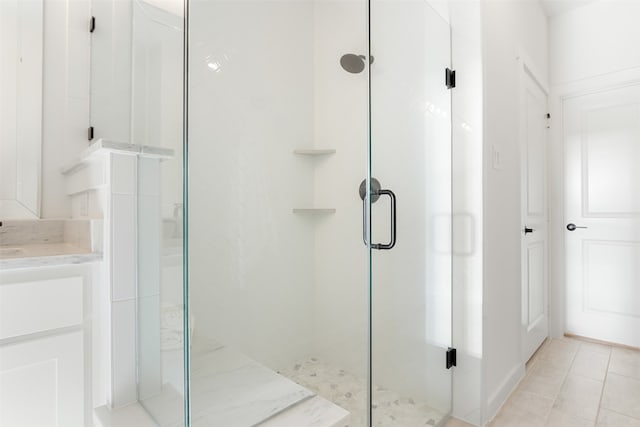 bathroom featuring walk in shower, tile patterned flooring, and vanity