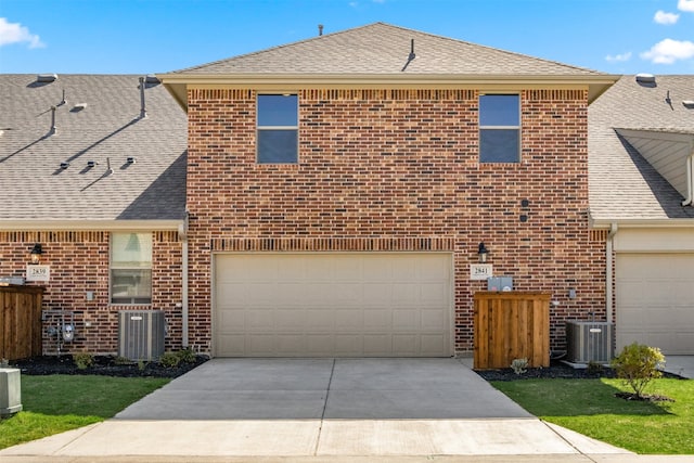 view of front of property featuring a garage and central AC