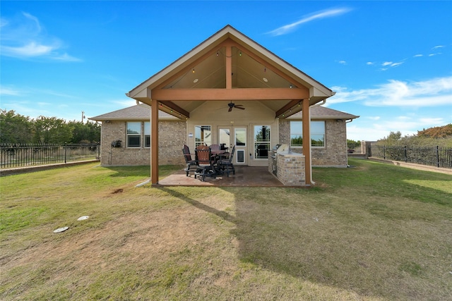 rear view of house featuring a yard, an outdoor kitchen, ceiling fan, and a patio area