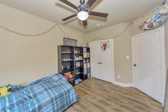 bedroom with hardwood / wood-style flooring, ceiling fan, and a closet