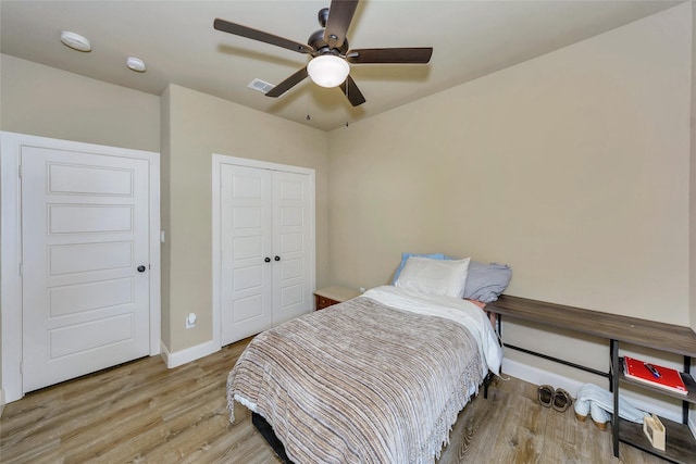 bedroom featuring ceiling fan, light hardwood / wood-style floors, and a closet